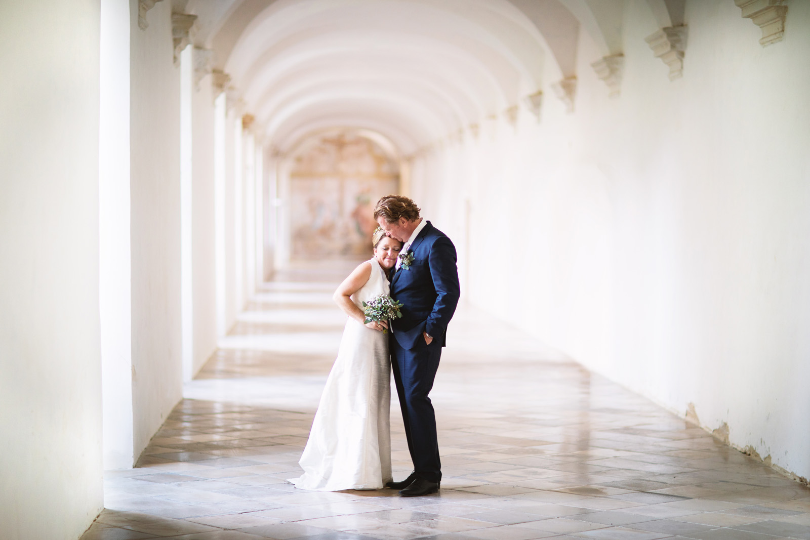 Verliebtes Brautpaar im Klostergang